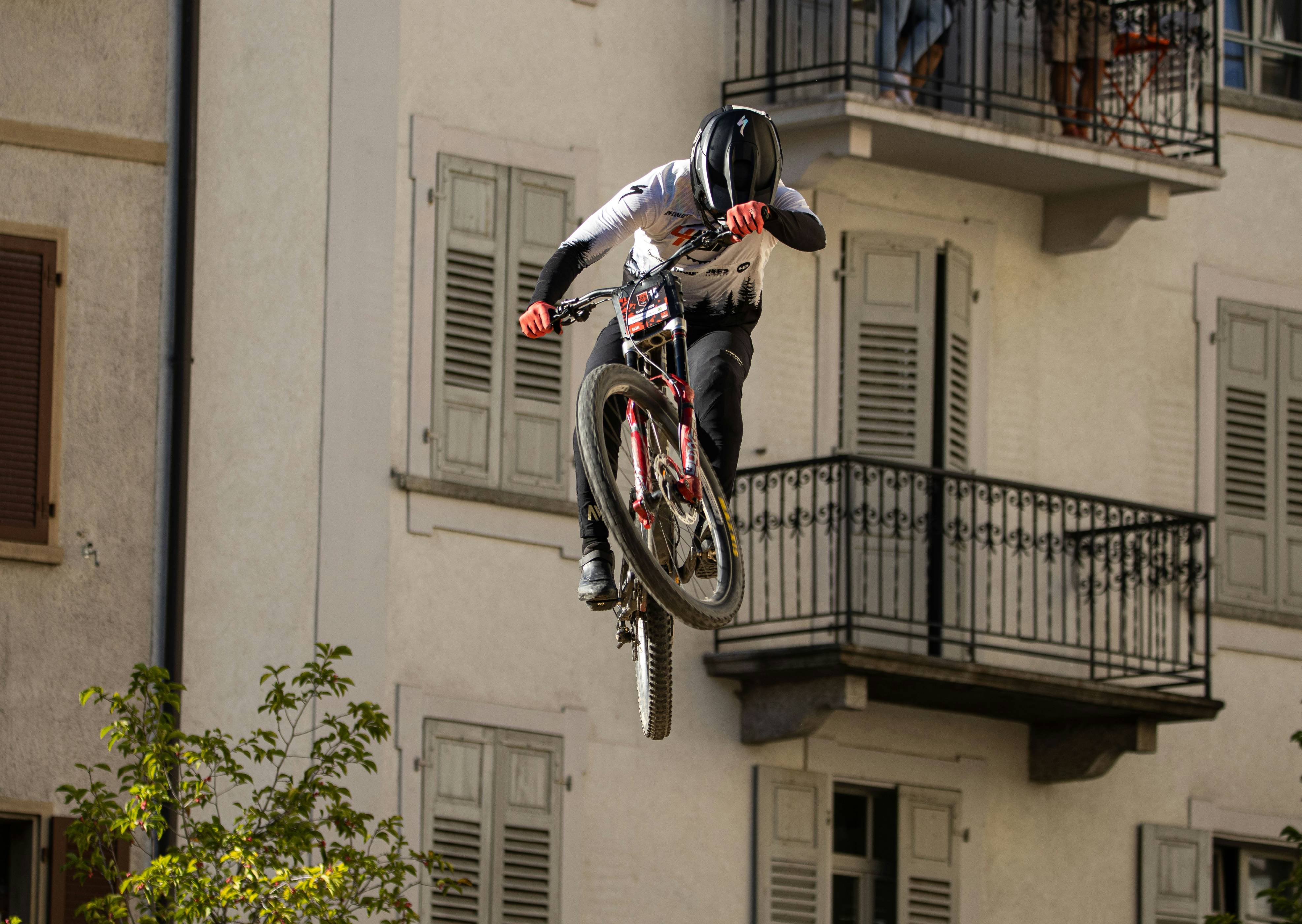 Man on bicycle jumps off building balcony